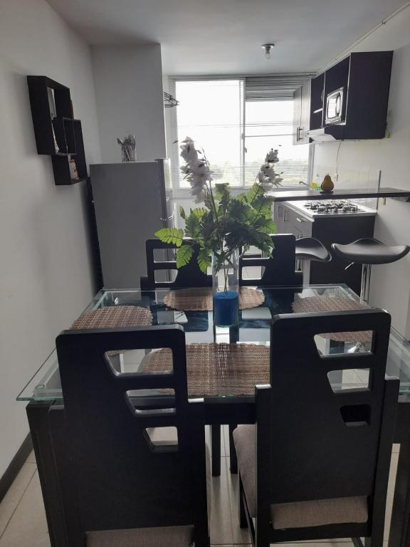 a kitchen and dining room with a table and chairs at Apartamento y Piscina a 3' del Parque del Cafe in Montenegro