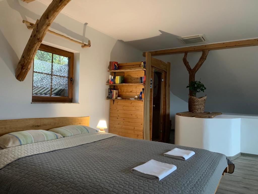 a bedroom with a bed with two towels on it at Zerko Holiday Home - Vineyard Chalet With Sauna and Jacuzzi FREE in Mirna