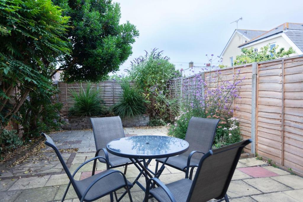 a patio with a table and chairs and a fence at Tankerton Town House, 1 parking space, 150m beach in Whitstable