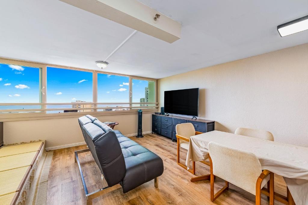 Zimmer mit einem Tisch, einem Sofa und einem TV in der Unterkunft Island Colony 3821 in Honolulu