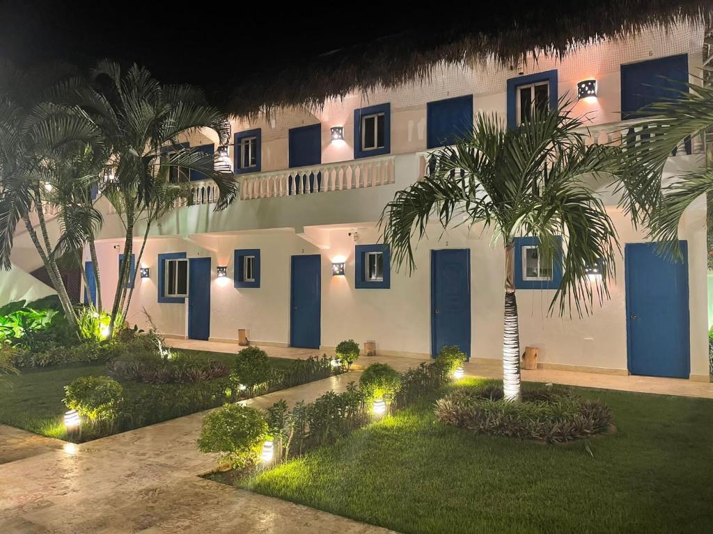 un patio de un edificio con palmeras y luces en Nuovo Hotel Playa Catalina, en La Romana