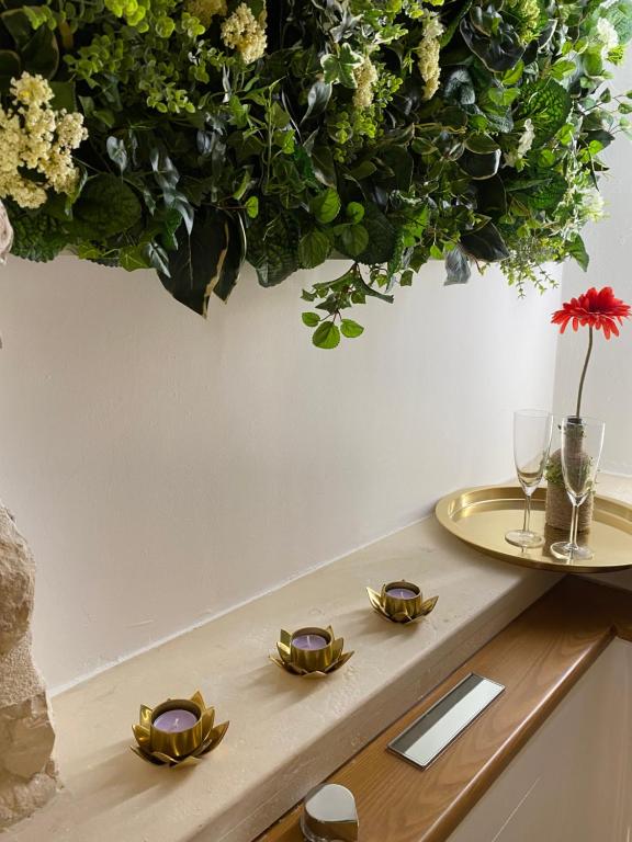 una mesa con gafas y un arreglo floral en una pared en DIMHORA, en Giovinazzo