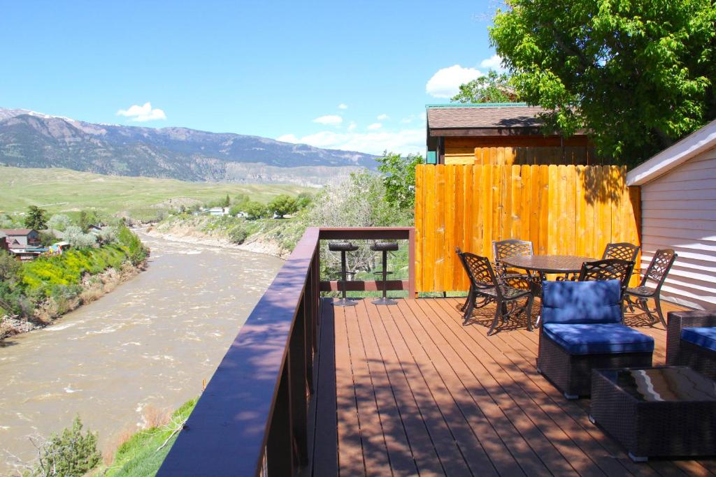 a balcony with a table and chairs and a river at Yellowstone Treasure Guesthouses on the River in Gardiner
