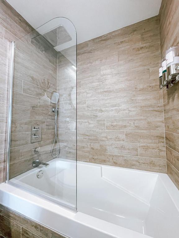 a bathroom with a white tub and a shower at Complexe LIVTremblant by Gestion ELITE - LIV6 in Mont-Tremblant