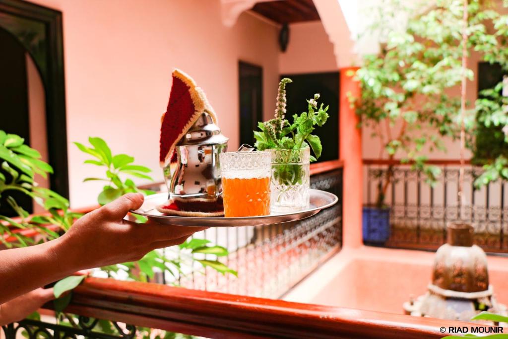 a person holding a plate of food on a balcony at Riad Mounir in Marrakesh