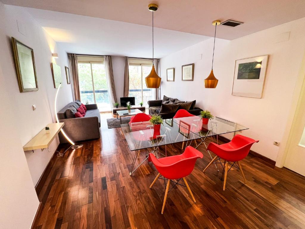 sala de estar con mesa de cristal y sillas rojas en Baron Suites, en Valencia