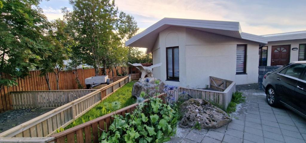 uma casa com uma cerca e um carro estacionado em frente dela em Lovely 2-bedroom apartment in Kopavogur em Reykjavík