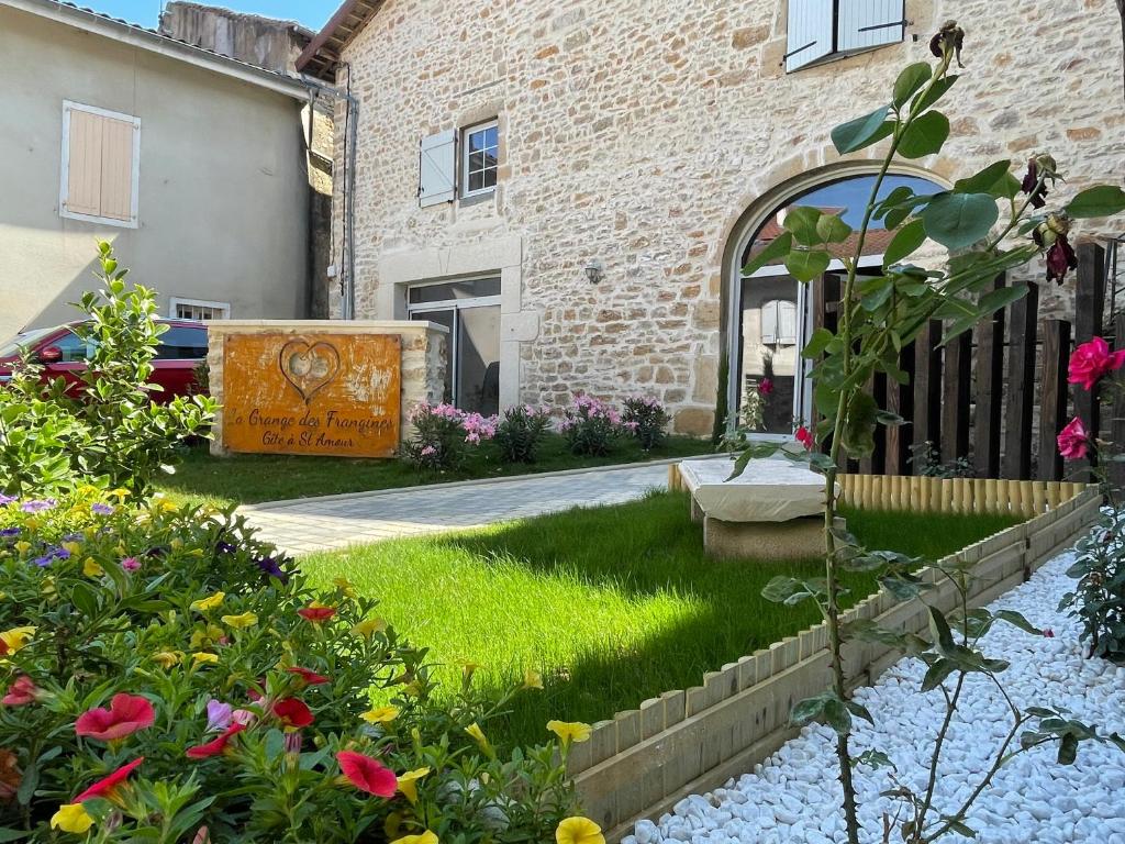 a garden in front of a building with flowers at LA GRANGE DES FRANGINES in Saint-Amour