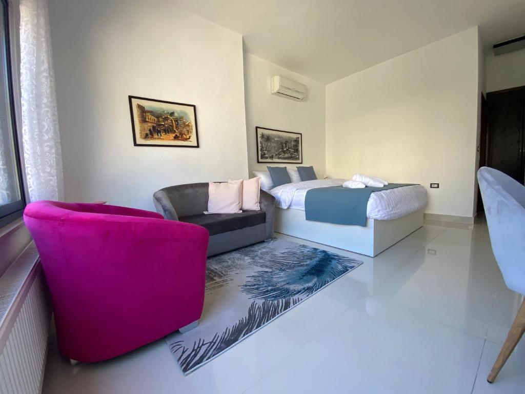 a bedroom with a bed and a couch and a chair at Lemon Tree Residence in Amman