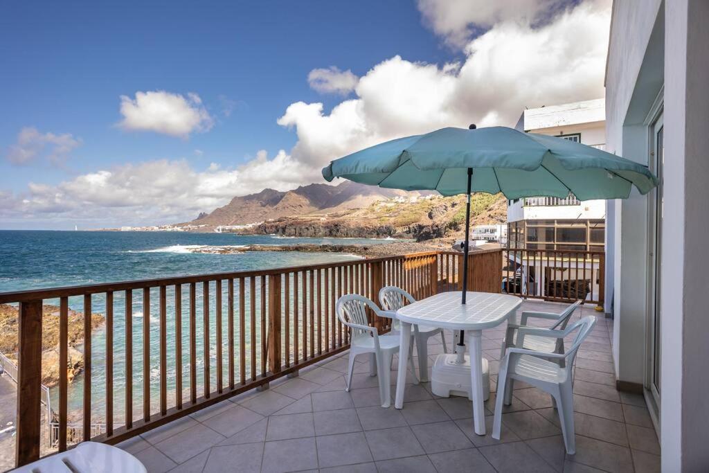 Una mesa y sillas en un balcón con vista al mar. en Brisas de Jover, en La Laguna