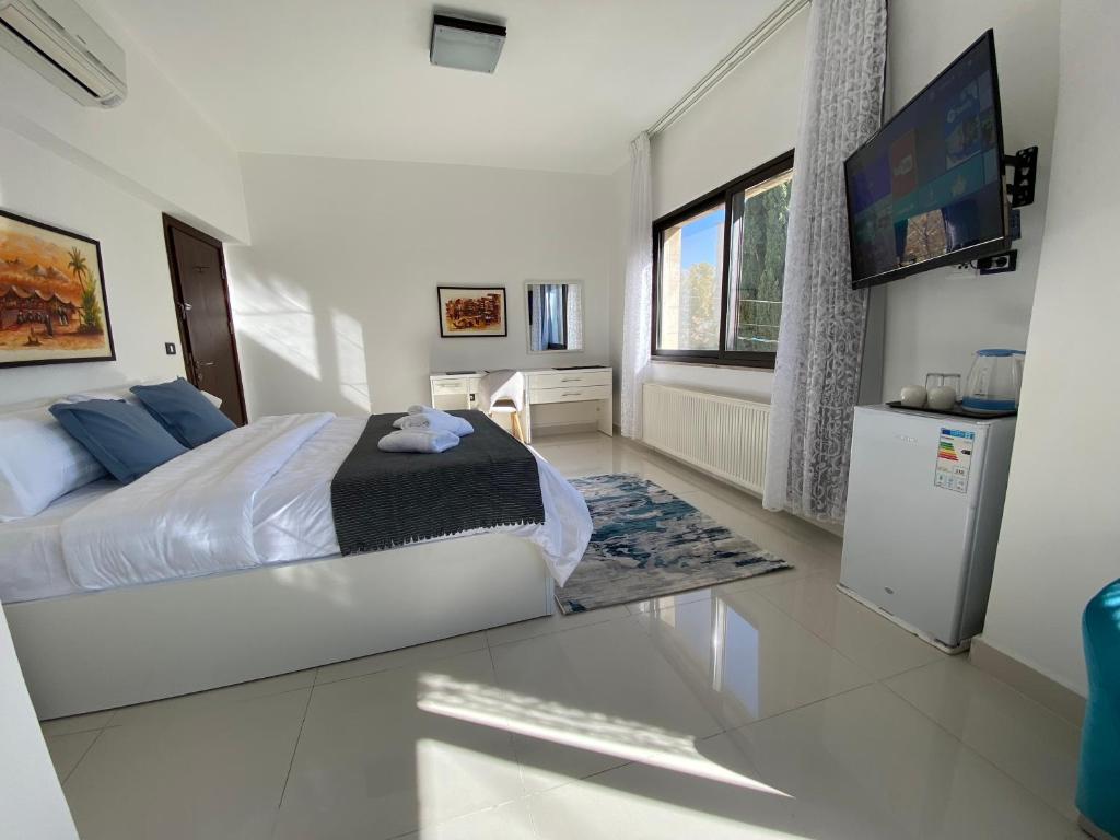 a bedroom with a bed and a flat screen tv at Lemon Tree Residence in Amman