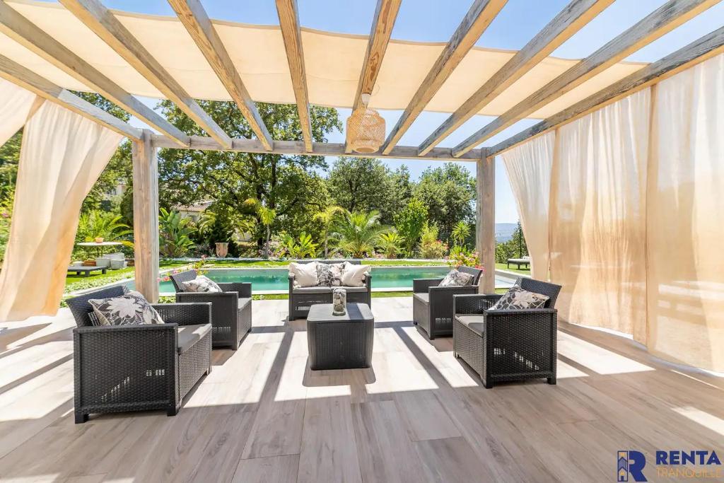 um pátio com mobiliário e uma piscina ao fundo em Cannes Hills Lovely Villa Pool & Garden em Le Cannet