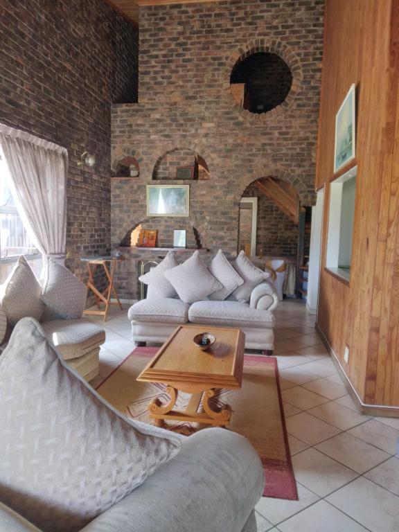 a living room with two couches and a table at Hamba Kancane Ma-Africa Guest House in Graskop