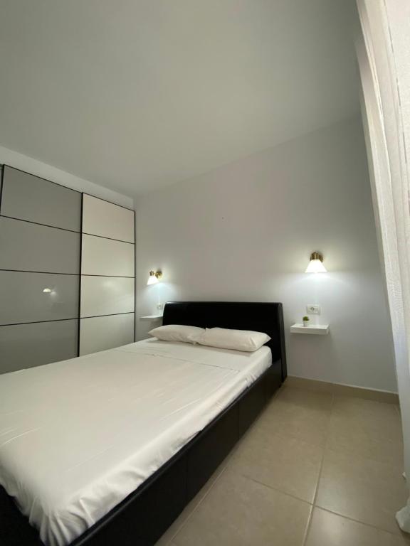 - une chambre avec un grand lit et des draps blancs dans l'établissement APARTAMENTO EN LOS CRISTIANOS - FREE WIFI, à Los Cristianos