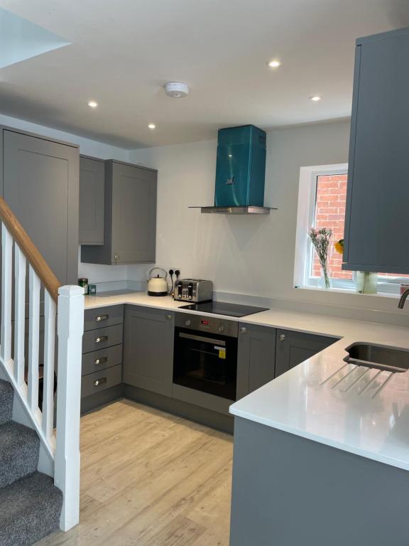 a kitchen with gray cabinets and a counter top at Sea Breeze Cottage Swanage Bay in Swanage