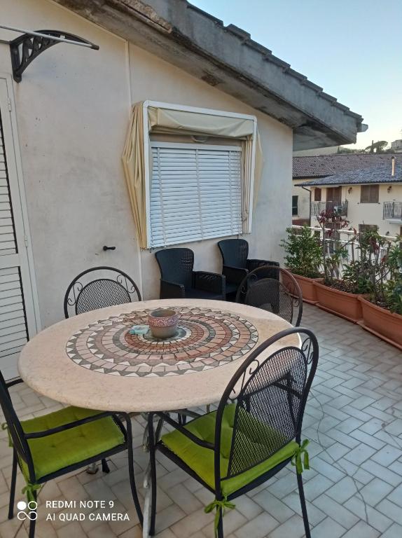 un patio con tavolo e sedie sul balcone. di IL MULINO Appartamento Itri centro 150 m2 con ampio terrazzo completo di tutti i comfort a Itri