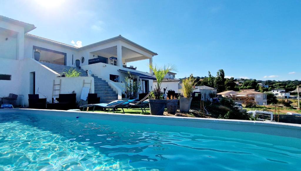 una casa con piscina frente a una casa en Villa Bistinetti Rez de villa tout confort avec piscine, en Penta-di-Casinca