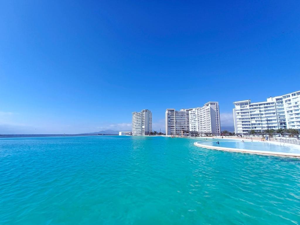 a large body of water with buildings in the background at Departamentos Laguna del Mar in La Serena