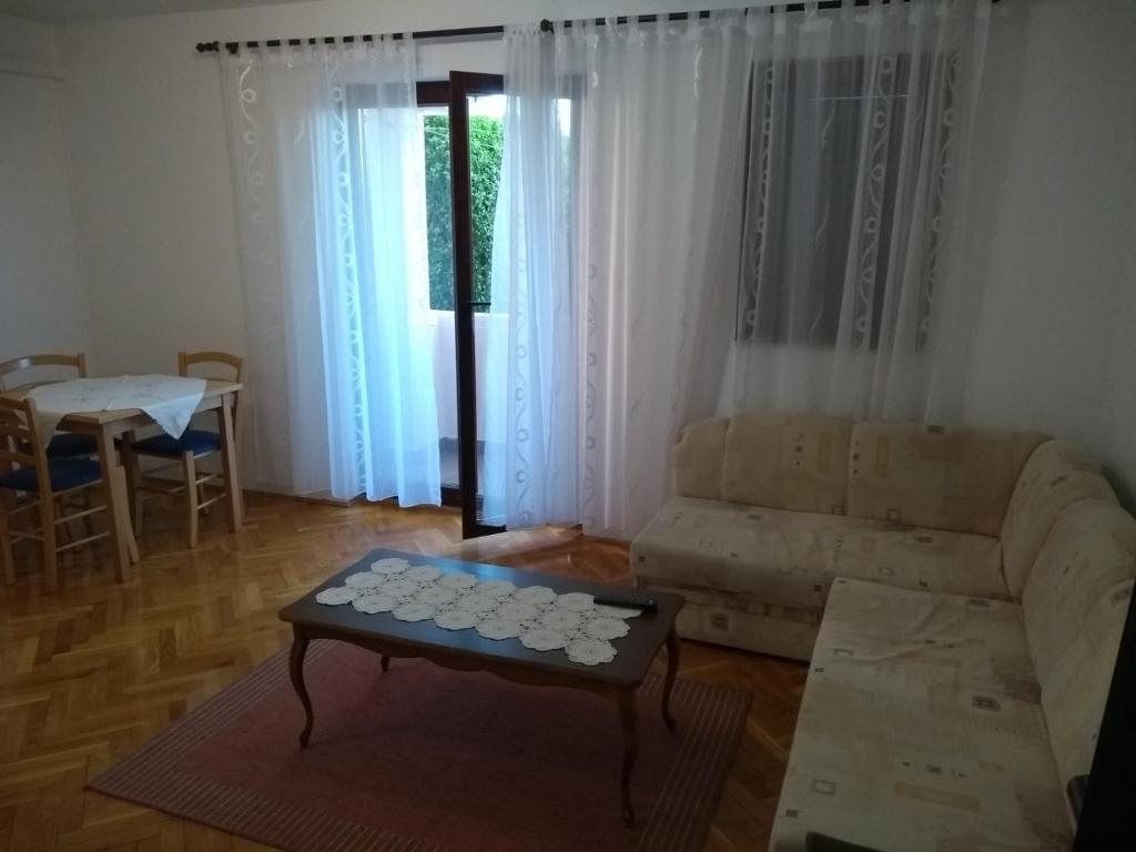 een woonkamer met een bank en een tafel bij Apartments with a parking space Crikvenica - 17675 in Crikvenica
