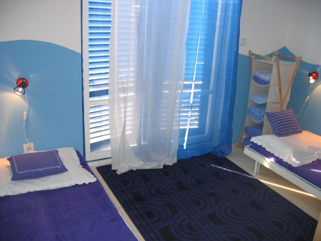 a room with a window with blue curtains and a rug at Family friendly apartments with a swimming pool Kaprije - 17692 in Kaprije