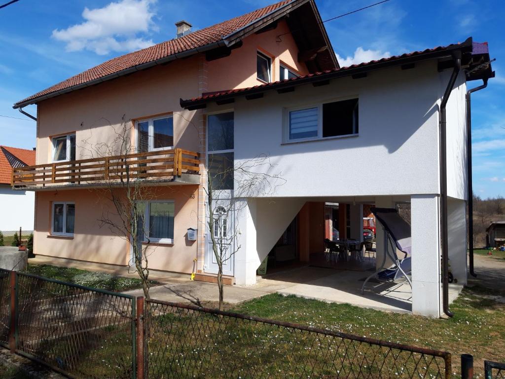 a white house with a porch and a fence at Apartments with a parking space Lipovaca, Plitvice - 17657 in Rakovica