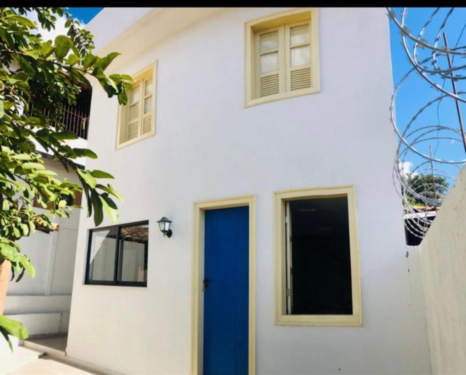 a white house with a blue door at Casa Ouro no centro de Diamantina in Diamantina