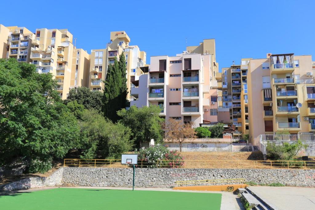 a tennis court in front of some apartment buildings at Apartments with WiFi Split - 17706 in Split