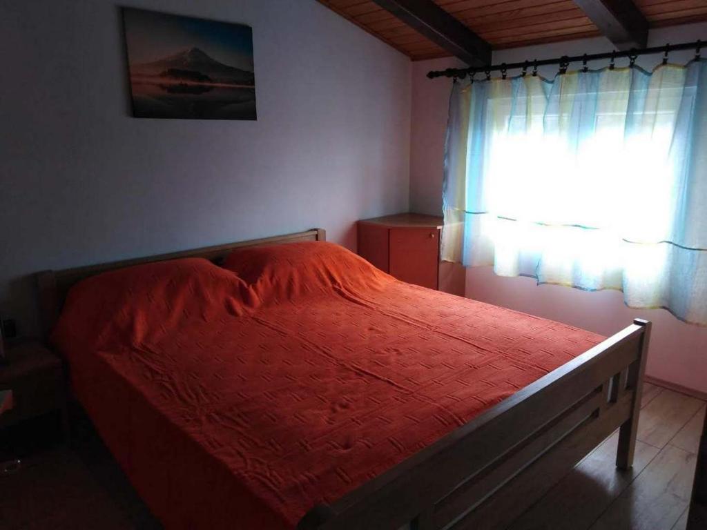 Apartment Silba 17603b في سيلبا: غرفة نوم بسرير احمر مع نافذة