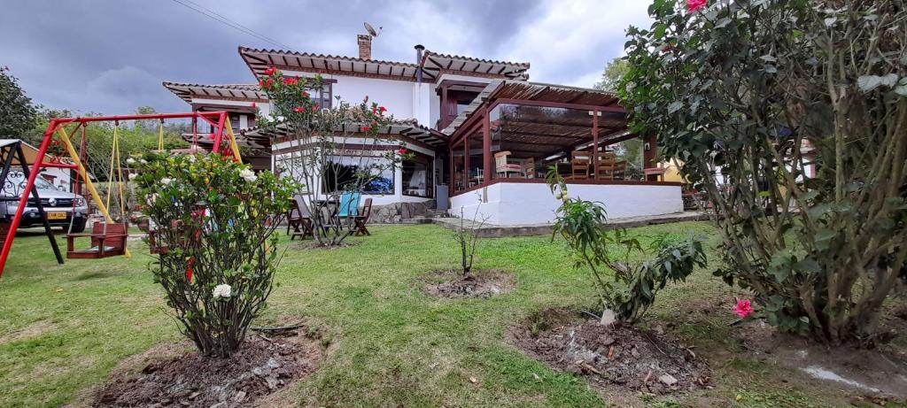 a house with a playground in the yard at Casa Hotel San Pedro in Villa de Leyva