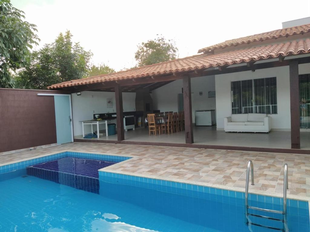 a villa with a swimming pool and a house at Rancho do Pedro in Capitólio
