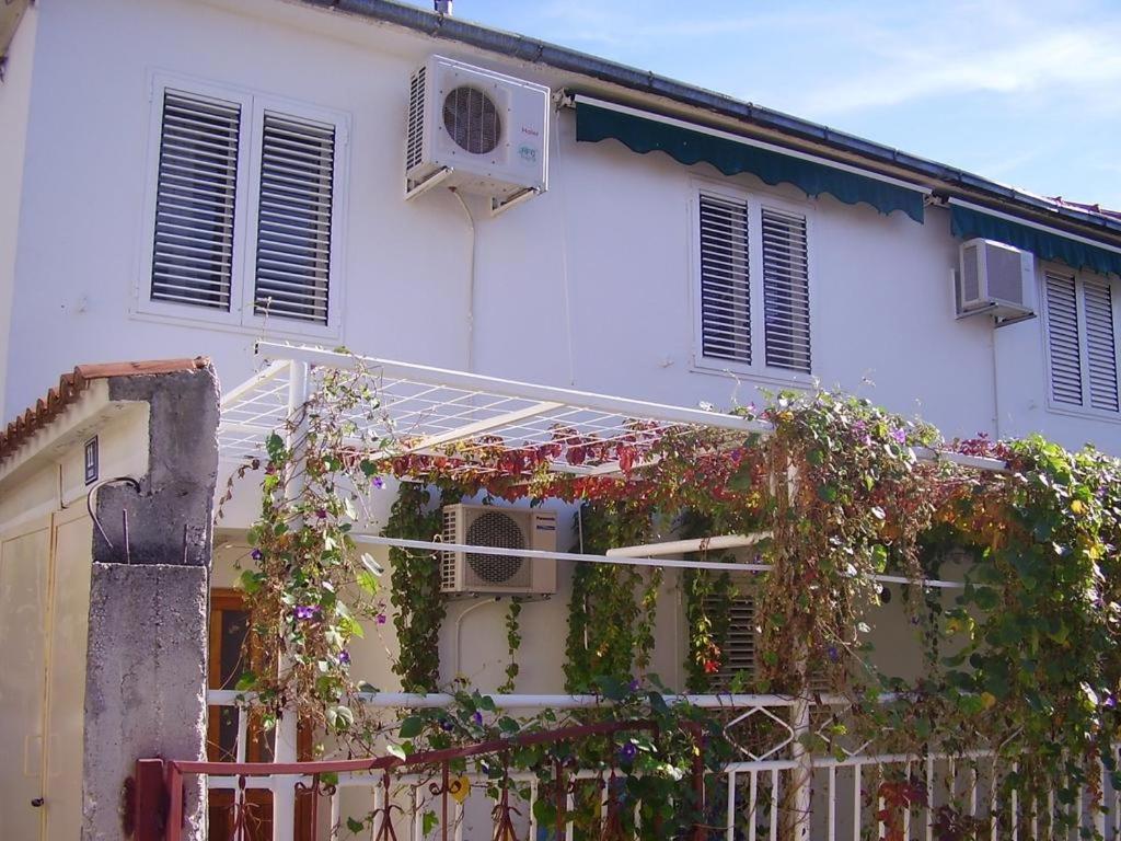 une maison blanche avec des plantes et une clôture dans l'établissement Apartments with WiFi Kastel Kambelovac, Kastela - 17732, à Kaštela