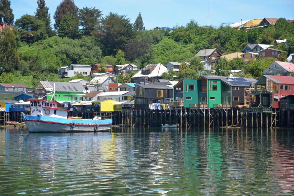 a group of houses on a dock next to the water at Palafito Verde Apart Hotel in Castro