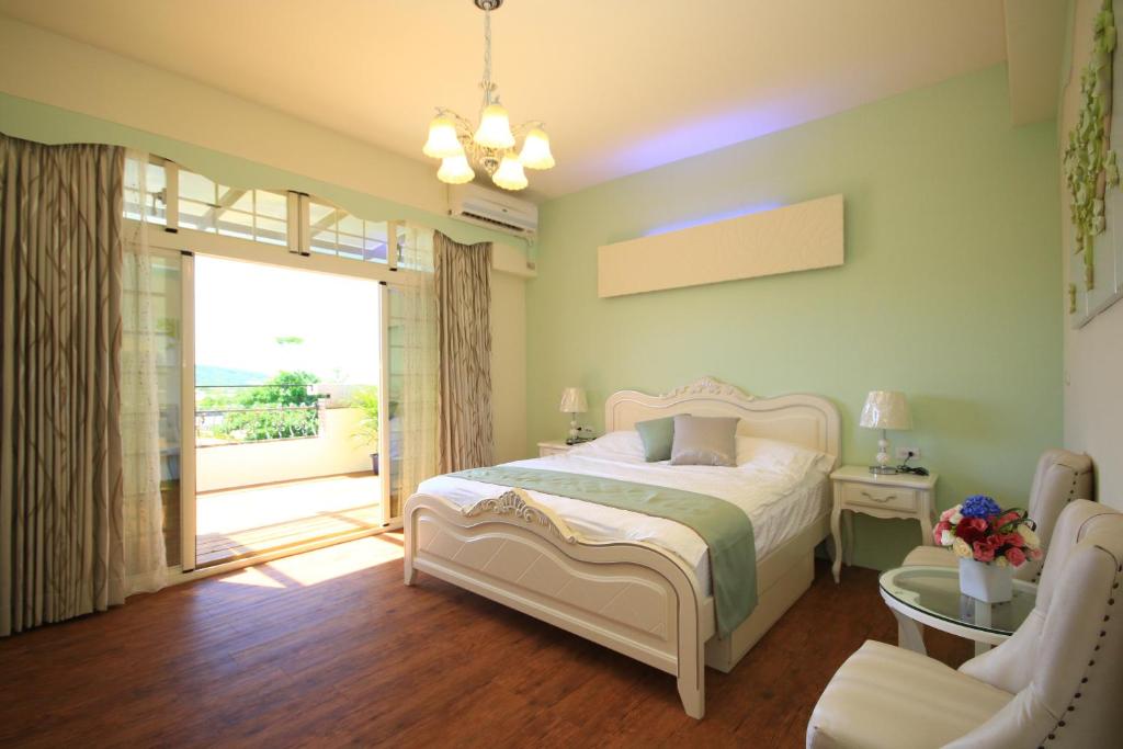 1 dormitorio con 1 cama y puerta corredera de cristal en Sunny Breeze Garden Homestay, en Jiali