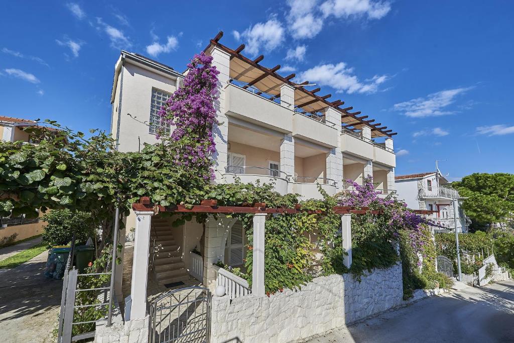 una casa con flores a un lado. en Apartment Mavarstica 17821b, en Trogir