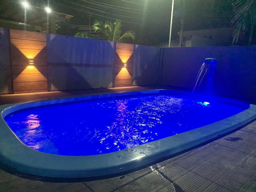 ein Schwimmbad in der Nacht mit Lichtern im Hinterhof in der Unterkunft Casa com 3 Suites à 200m da Praia - Barra de São Miguel in Barra de São Miguel