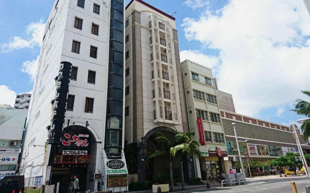 a tall white building on a city street at Hotel Sun Queen in Naha