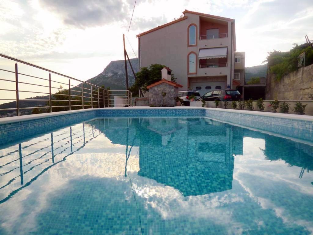 una piscina di fronte a una casa di Family friendly apartments with a swimming pool Klis, Split - 17987 a Klis