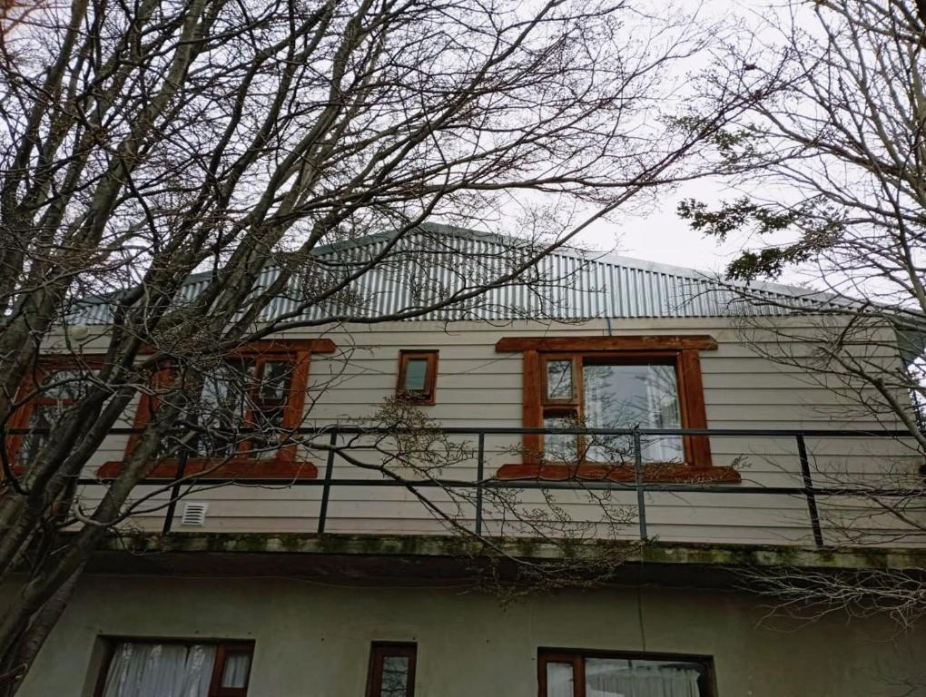 烏斯懷亞的住宿－Oshovia Mirador Martial，白色的房子,设有橙色窗户和阳台