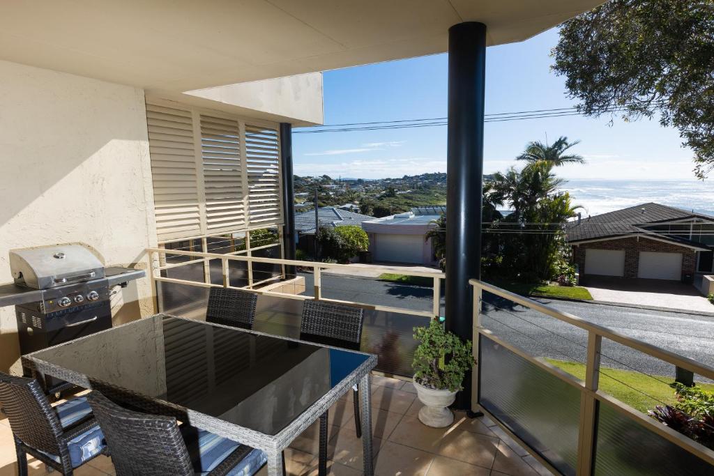 a balcony with a table and chairs and a view of the ocean at Seachange in Forster