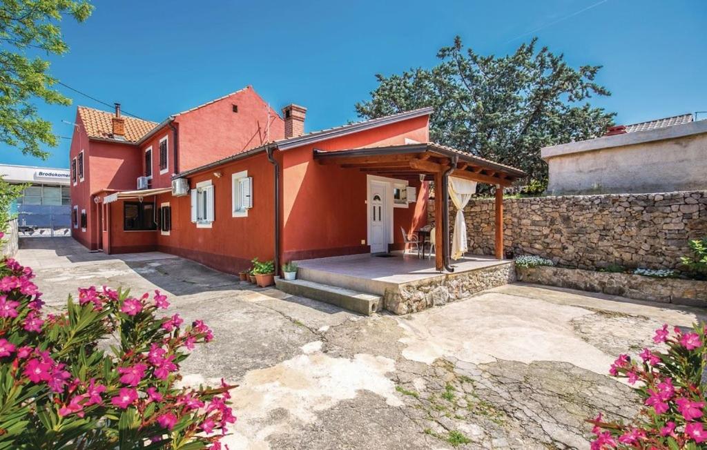 ein Haus mit einem roten Haus mit einer Steinmauer in der Unterkunft Apartments for families with children Krasica, Rijeka - 18032 in Krasica