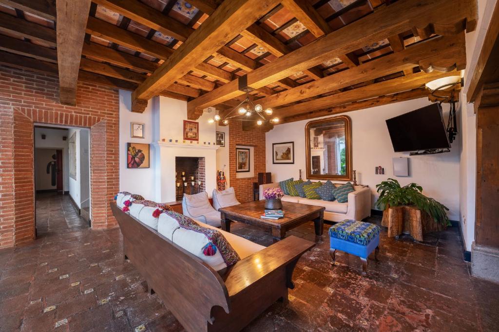 a large living room with couches and a tv at Barbara's Boutique Hostel in Antigua Guatemala