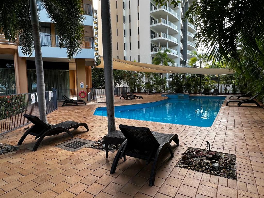 patio z krzesłami i basenem w budynku w obiekcie Darwin Esplanade Central Official w mieście Darwin