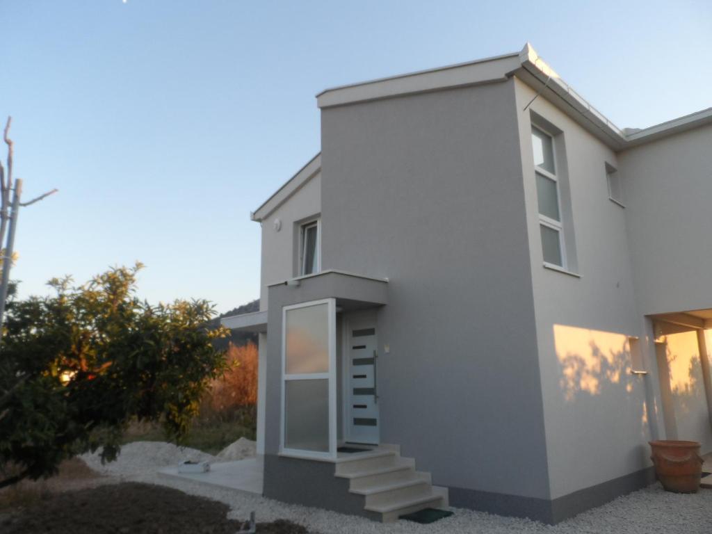 Una casa blanca con escaleras al costado. en Apartments with a parking space Opuzen, Neretva Delta - Usce Neretve - 18070, en Opuzen