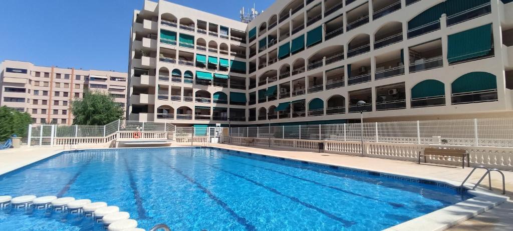 a swimming pool in front of a building at vacaciones en pineda con 2 piscinas, playa a 5 min in La Pineda