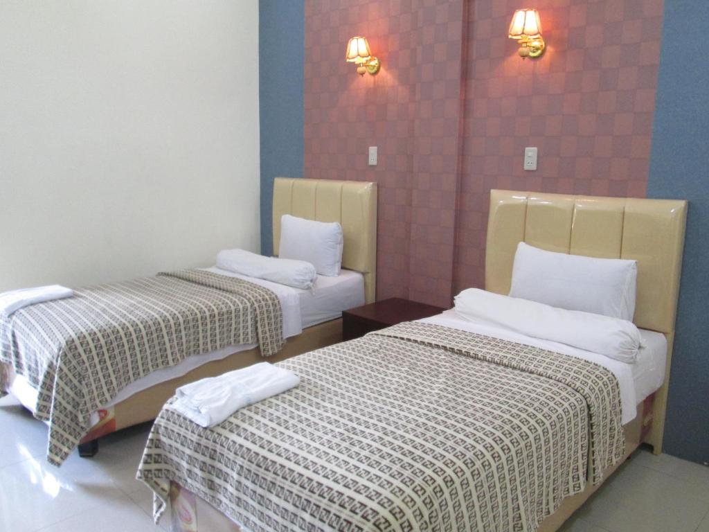 Habitación con 2 camas en una habitación en Permata Land Hotel & Resort, en Rantauprapat