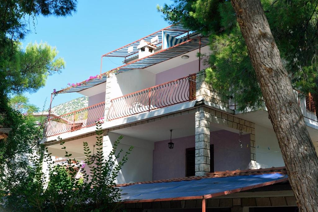a house with a balcony on top of it at Apartments by the sea Ivan Dolac, Hvar - 18100 in Jelsa