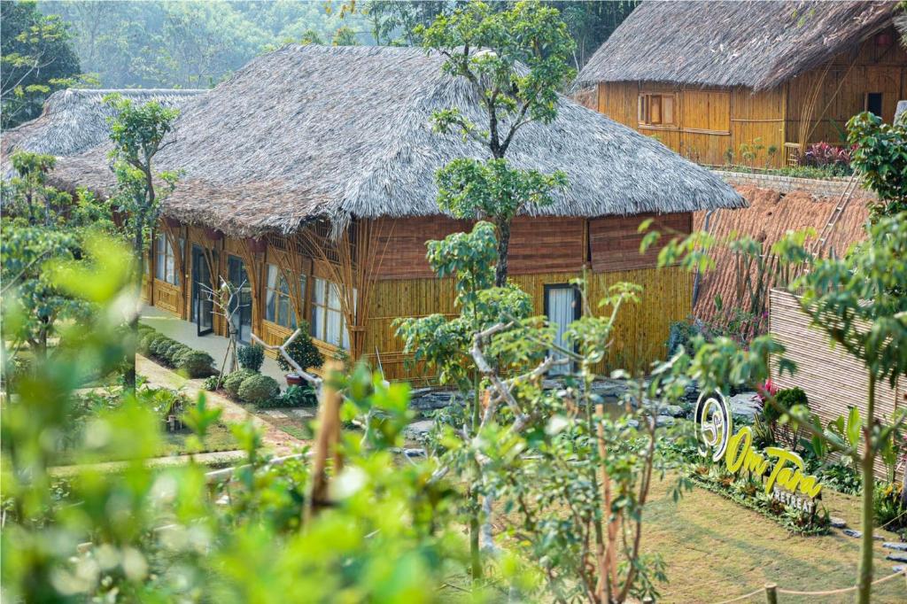 a wooden house with a thatch roof at OMTARA RETREAT in Yen Bai