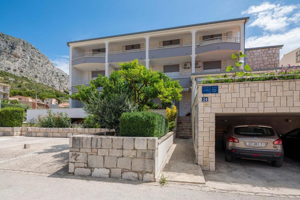 a car parked in a parking lot in front of a building at Apartments and rooms by the sea Duce, Omis - 18155 in Omiš
