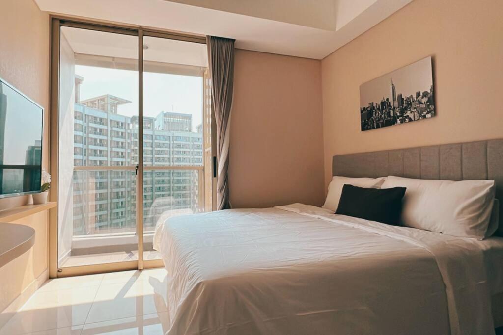 Tempat tidur dalam kamar di Cozy Studio Suite in Taman Anggrek Residences