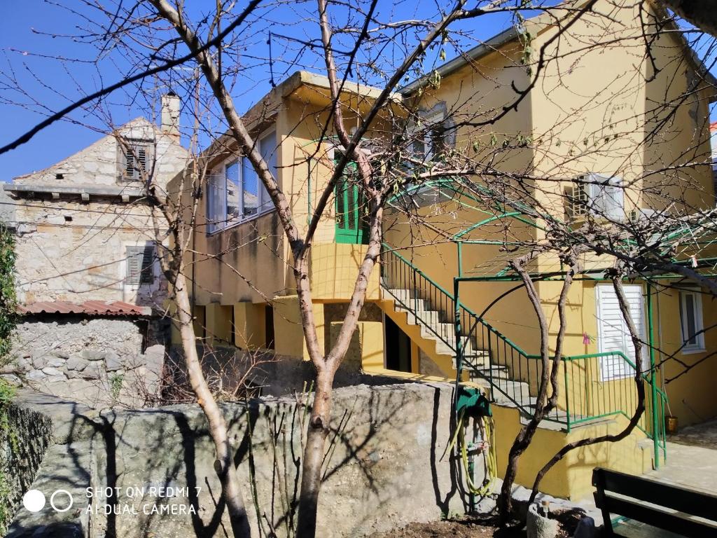 ein gelbes Haus mit einer Treppe davor in der Unterkunft Apartments by the sea Krapanj, Sibenik - 18180 in Šibenik